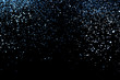 Splash of blue sparkles on black background.