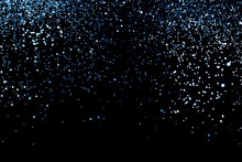 Splash Of Blue Sparkles On Black Background.