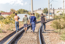 Young People Teenagers Walk On The Railroad Tracks