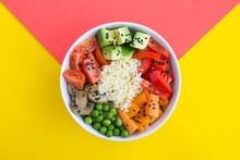 Vegan Poke Bowl With Couscous  And Vegetables In The White Bowl In The Center Of The Bicolor Background. Top View. Copy Space. Closeup.