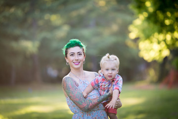 Young Caucasian mother with short green hair playing with a toddler boy