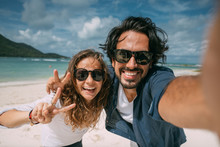 A Pair Of Lovers Take A Selfie On A Tropical Beach.