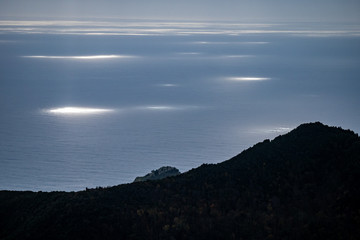 sunbeams stand out on the sea like floodlights in a cloudy day