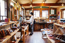 Japanese Woman Browsing Merchandise In A Leather Shop.