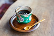 © Mint Images - High angle close up of Japanese condiment in green bowl on wooden plate.
