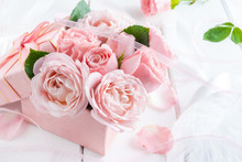 Beautiful Pink Flowers In Gift Box With Ribbons Closeup On White Wooden Table.