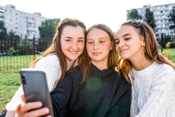 3 girls girlfriends teenagers selfie photo phone camera autumn day city, happy smiling, rejoicing having fun after school college. Emotions relaxation entertainment, online Internet, social networks.