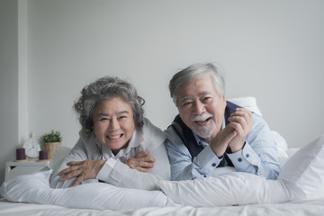 Wall Mural - elderly couple caucasian senior man and woman sleep on bed and smiling in white blanket in bedroom, retirement health care with love lifestyle concept