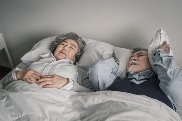 Wall Mural - elderly couple caucasian senior man and woman sleep on bed and snoring in white blanket in bedroom, retirement health care with love lifestyle concept