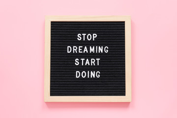 Stop Dreaming Start Doing. Motivational quote on letterboard on pink background. Top view Flat lay Concept inspirational quote of the day