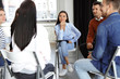 © New Africa - Psychotherapist working with patients in group therapy session indoors