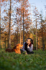 Poster - Golden retriever sitting with his owner on the grass