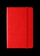 Red closed notebook isolated on black