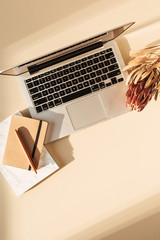 Wall Mural - Flat lay view of laptop, protea flower and notebook. Minimal girl boss blog work concept. Freelancer home office table desk workspace.