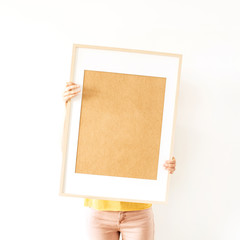 Young pretty woman hold blank photo frame with empty mockup copy space. Minimal art concept.