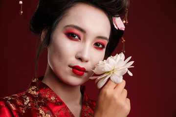 Poster - Image of beautiful geisha woman in japanese kimono holding flower