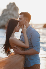 Couple in love at dawn by the sea. Honeymoon trip. Man and woman traveling. Happy couple by the sea view from the back. Man and woman holding hands. Couple in love on vacation. Follow me. Couple on a 