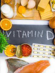 Wall Mural - Vitamin D in food as fish, caviar, orange, micro greens, cheese, eggs, mushrooms, milk, butter, corn, oil, products rich in vitamin D.