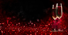 Two Champagne Glasses On Sparkling Red Bokeh Background. Valentine's Day Dinner Invitation. Christmas And New Year Holiday Party.