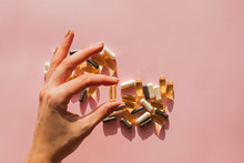 Woman's hand holding a pill or dietic supplement capsule