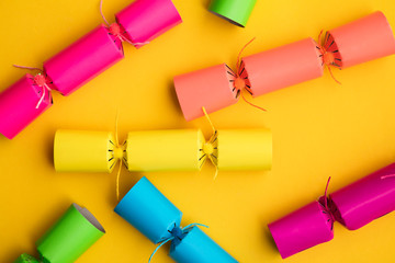 Wall Mural - Bright colourful Christmas crackers on a yellow background. festive layflat