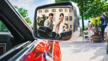 Beautiful Bride And Groom In The Mirror Of The Bride's Car