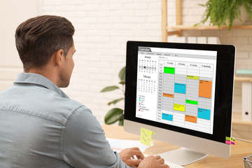 Man using calendar app on computer in office