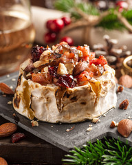 Baked Camembert cheese with bacon, nuts and cranberries.