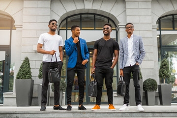 Wall Mural - four handsome young african men on the background of the building