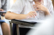 © panitan - high school,university student study.hands holding pencil writing paper answer sheet.sitting lecture chair taking final exam attending in examination classroom.concept scholarship for education abroad