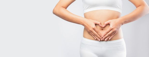 Close up woman hands made heart on belly isolated on white background banner size.health care digesting concept.