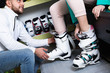 © JackF - Closeup of ski boots on female legs during fitting in shop of sports equipment