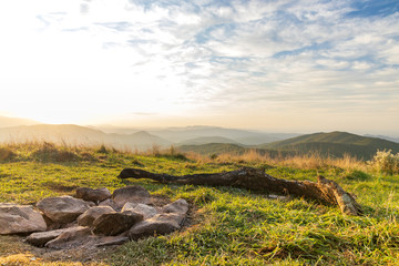 Sunset view from Max Patch bald over the Great Smoky Mountains with rock firepit in foreground