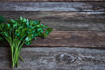 Wall Mural - Bunch of fresh green parsley on old rough wooden surface, healthy eating concept, selective focus