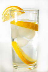 Glass of cold fresh water with slices of ice and lemon.