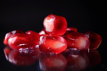 Wall Mural - Ripe pomegranate seeds closeup on a dark background. Spectacular macro photo. The concept of wholesome organic food, vegetarianism, fresh fruit harvest.