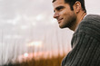 © Raymond Forbes LLC/Stocksy - Portrait of Happy Handsome man Outdoors in Fall at Beach