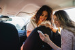 © Michela Ravasio/Stocksy - Female friends using their cell phones in the car