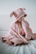 A Baby Girl Sitting In Her Pink Towel After A Lovely Bath