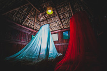 White And Red Mosquito Net Above The Bed In A Typical Cabana Or Cottage House On The Beach In Puerto Escondido In Mexico. Roof Is Made Of Palm Leaves And Walls From Wood.