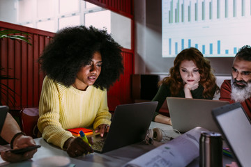 Afro casual woman using laptop in meeting room