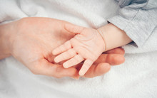 Close Up Baby Hand On Mother's Hands