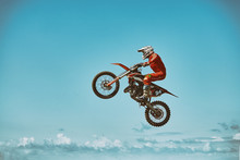 Extreme Sports, Motorcycle Jumping. Motorcyclist Makes An Extreme Jump Against The Sky. Film Grain Effect, Illumination
