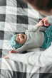 © Dmytro Bilous/Stocksy - baby is playing with mom lying on the bed and laughing
