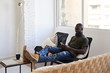 © Ivan Gener/Stocksy - Relaxed black male at home.