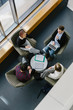 © Raymond Forbes LLC/Stocksy - Overhead View of Business Meeting with Four People