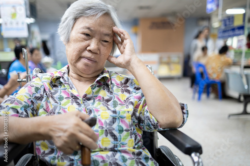 Senior asian patient in wheelchair waiting for a long time,medical examination with the doctor in the hospital,elderly people feel stress, bored and tired of waiting for medical specialist examination