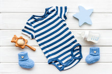 Blue Bodysuit For Baby Boy Near Children's Accessories On White Wooden Background Top-down