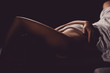 Close up side view on young sensual woman covered breasts holding hand white sheets over her body red and blue illuminated lying on the bed