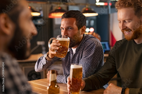 Fotomural Man drinking draft beer with friends